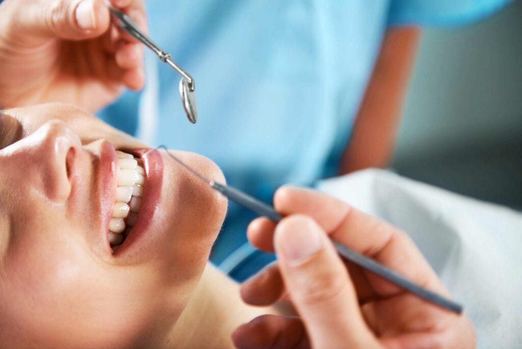 patient smiling while having her teeth examined